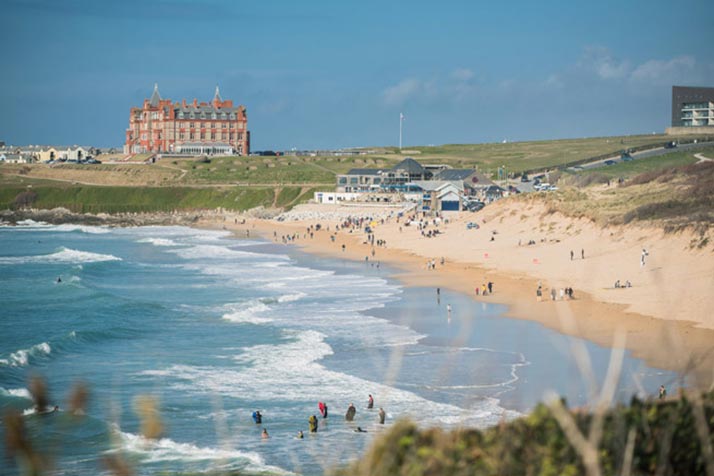 Waves roll into the beach at Fistral with The Headland Hotel in the background