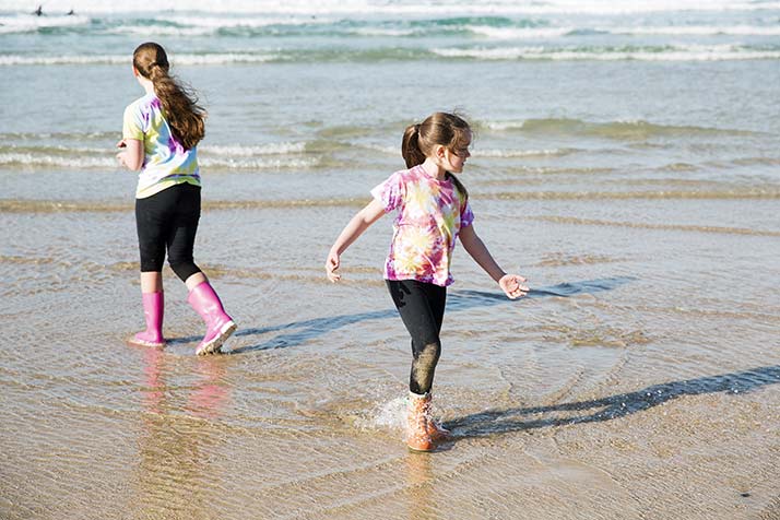 Two girls splash in the sea at Perranporth