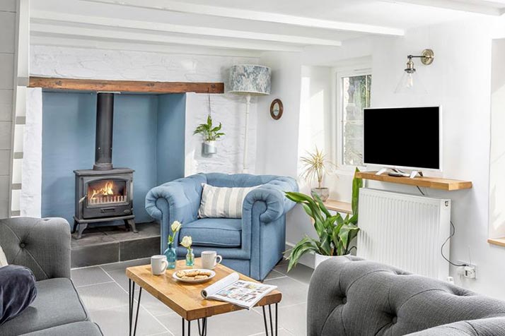 a cosy room shows a fireplace, armchair, sofas and coffee table