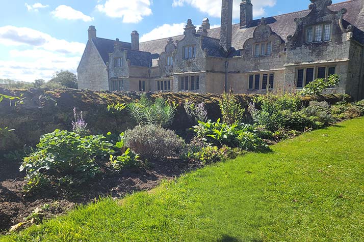 Trerice Manor House with lawn and shrubs in front